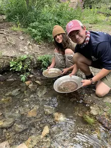 Two Troop 826 Scouts practicing an outdoor skill together beside a creek