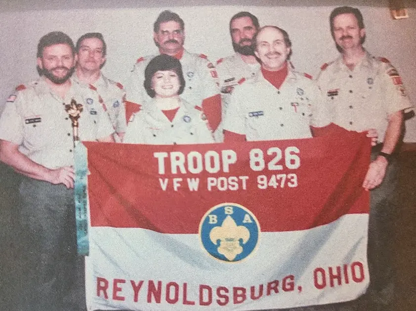 Troop 826 founding leadership team gathered behind the troop banner in 1996