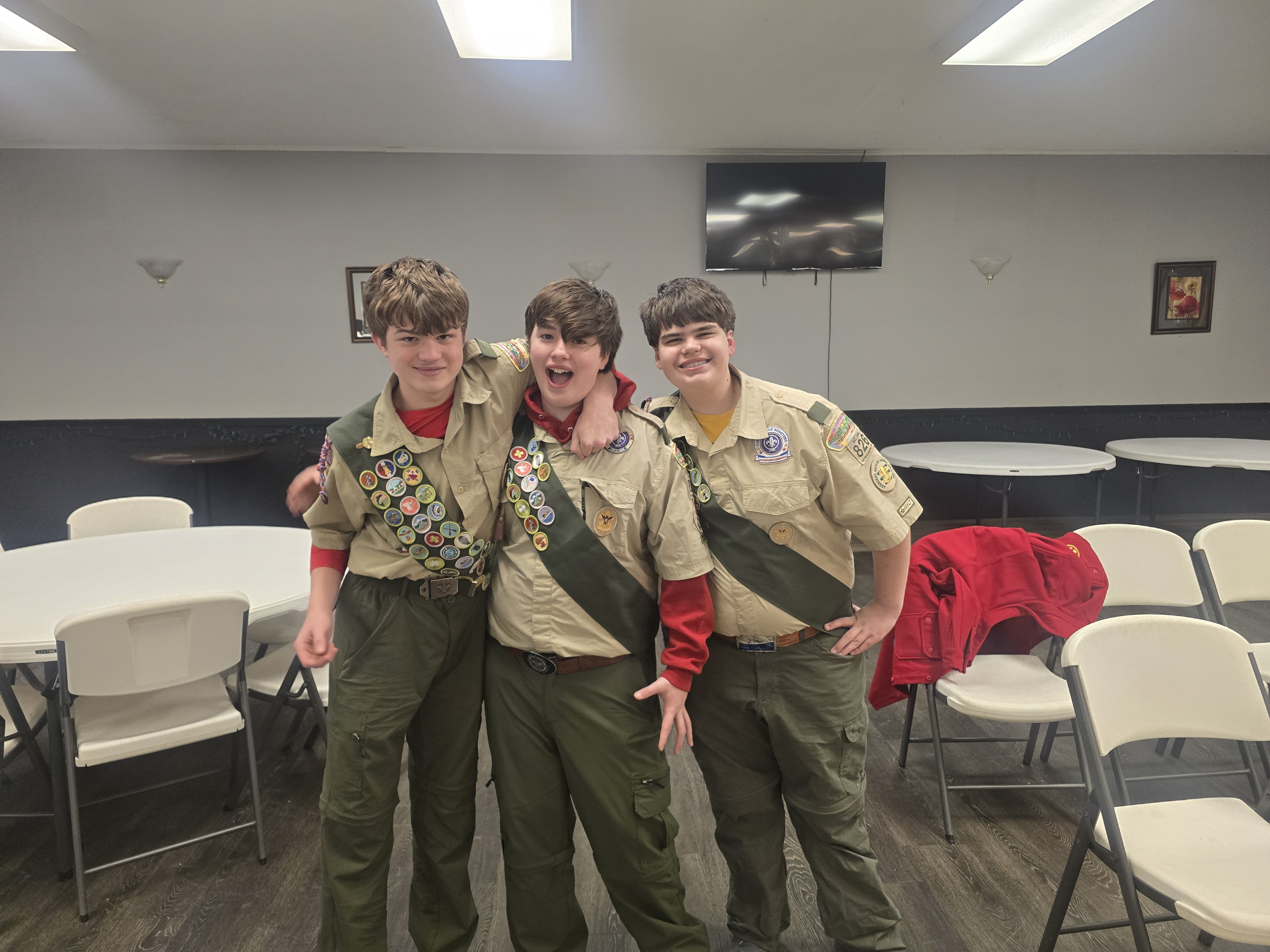 Three Troop 826 Scouts celebrating friendship and advancement together